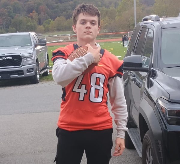 Lucian Breault, junior, stops to pose in front of the Elkins High School field. 